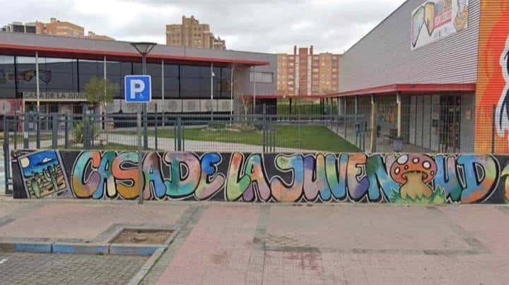 Vista frontal del complejo de la Casa de la Juventud con acceso peatonal y señalización de aparcamiento