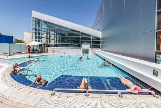 Piscina exterior de la Ciudad Deportiva Valdelasfuentes con personas disfrutando del sol