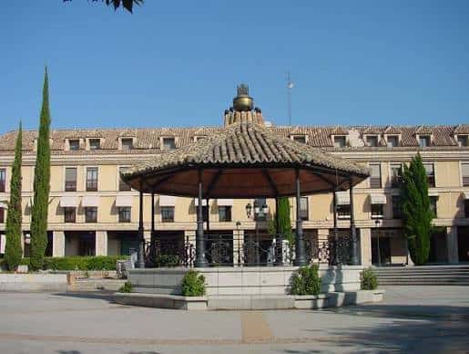 Vista frontal de la plaza con el kiosco de música y el edificio institucional al fondo