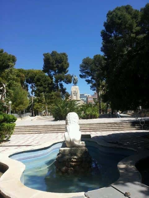 Plaza Castelar con la fuente del león y el monumento al fondo bajo un cielo despejado