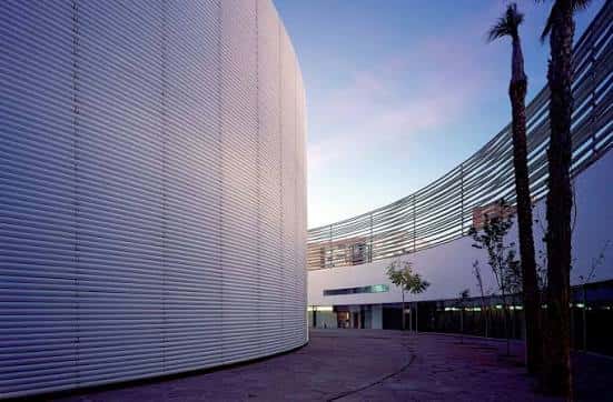Fachada exterior del edificio al atardecer con palmeras y diseño arquitectónico moderno