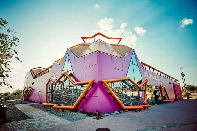 Vista exterior del edificio La Casa+Grande con su distintiva arquitectura geométrica y colores vibrantes