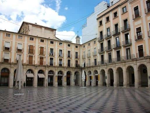 Plaza del Centenari con arcos y edificios históricos en un día soleado