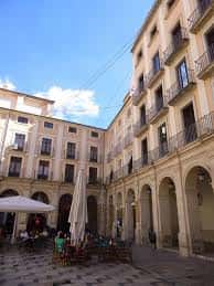 Área de la plaza con mesas al aire libre y arquitectura tradicional valenciana