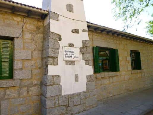 Fachada de la Biblioteca Municipal Sancho Panza con detalles en piedra y ventanas verdes