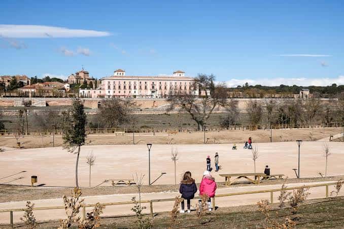 Vista panorámica del parque con zona de picnic y el Palacio de la Moraleja al fondo