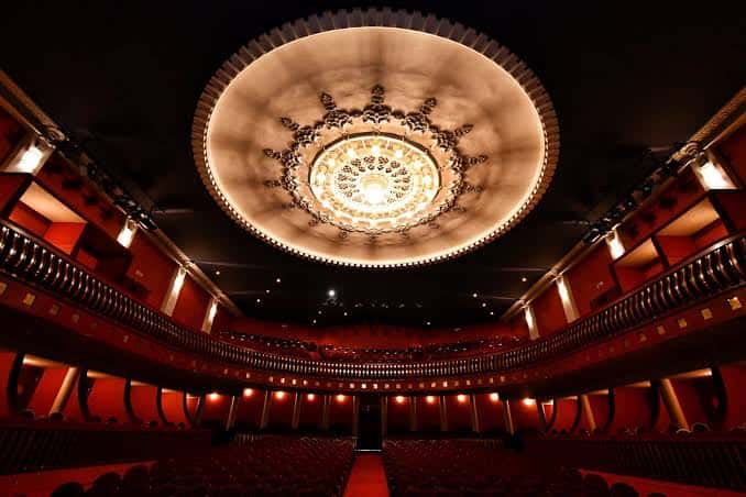 Vista interior del auditorio del Teatro Castelar con el techo decorado y las butacas rojas