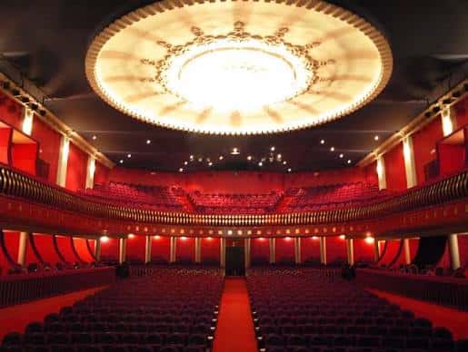 Interior del auditorio del Teatro Castelar con el techo iluminado y las butacas rojas