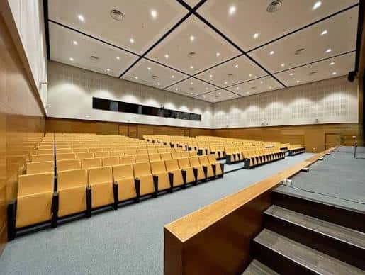 Interior del auditorio con butacas amarillas y escenario