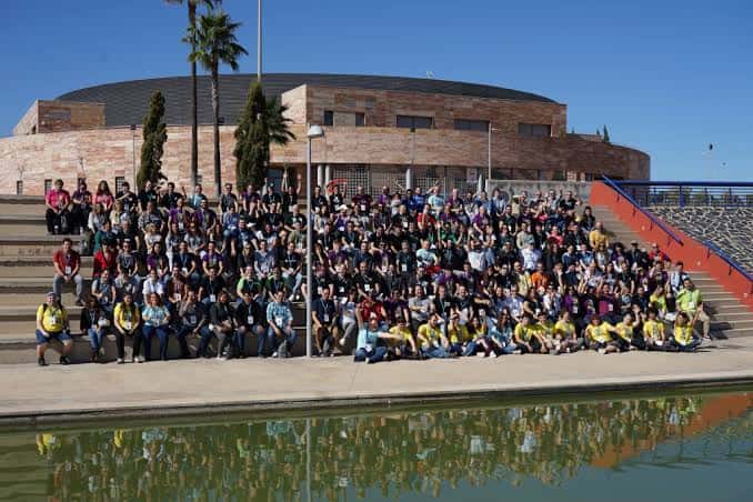Grupo de asistentes posando frente a la Ciudad del Conocimiento