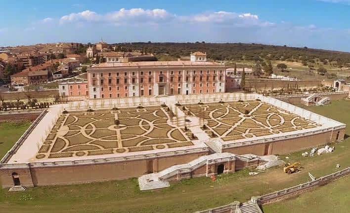 Vista aérea diurna del palacio y sus extensos jardines geométricos desde una perspectiva elevada