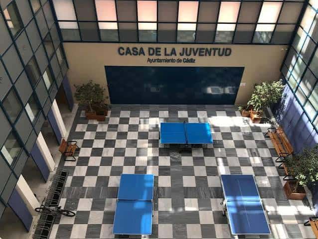 Vista aérea del patio interior con mesas de ping-pong y suelo a cuadros