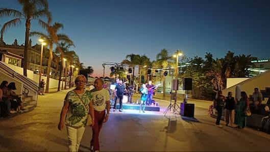 Vista nocturna del Anfiteatro de la Alameda del Río con escenario iluminado y público asistiendo a un evento