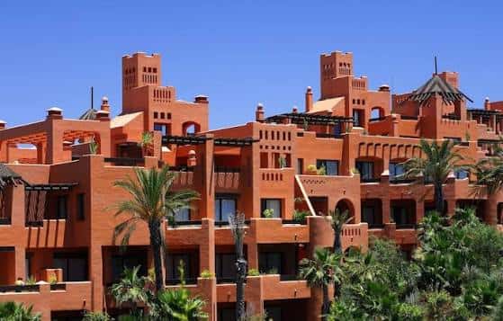 Fachada exterior del hotel con arquitectura de tonos terracota y detalles mediterráneos