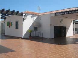 Fachada exterior de la Oficina de Turismo de Mijas con letrero visible y patio de baldosas