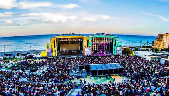 Vista panorámica del festival Marenostrum Fuengirola con escenario iluminado y multitud frente al mar