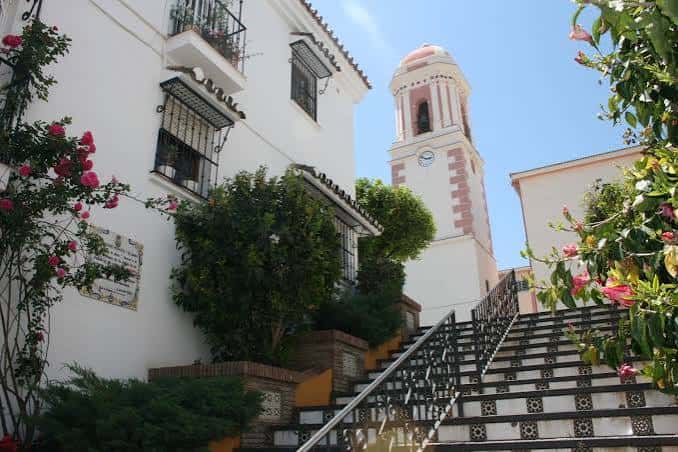 Vista de la Torre del Reloj con escalinata y flores