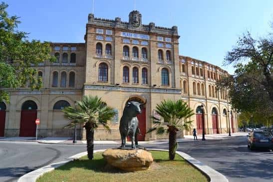 Vista exterior de la Real Plaza de Toros con la estatua del toro en primer plano
