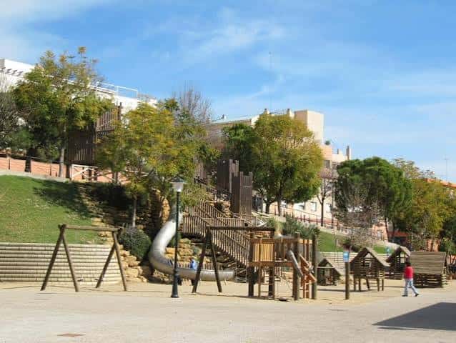 Área de juegos infantiles con toboganes y estructuras de madera