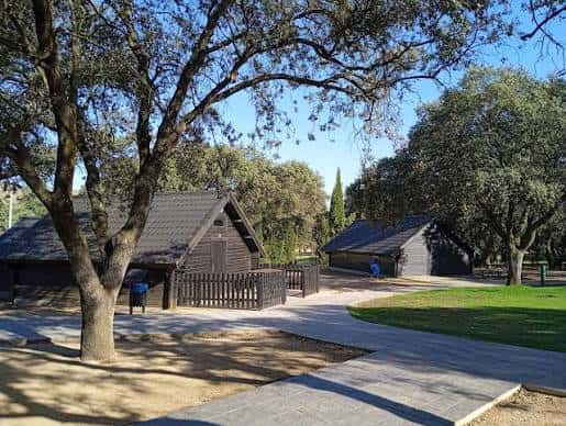 Cabañas de madera en el Parque Deportivo La Garza rodeadas de árboles y senderos
