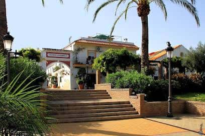Vista de la Plaza José Vázquez Espinosa con escaleras, palmeras y edificios blancos típicos de Estepona