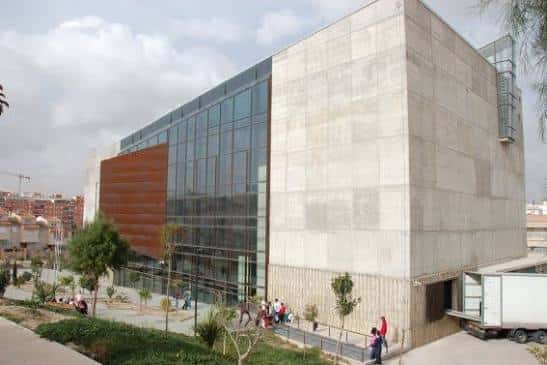 Fachada lateral del teatro con acceso peatonal y camión de carga