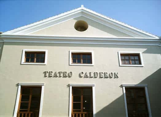 Fachada completa del Teatro Cervantes en Linares con vehículos en primer plano