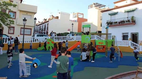 Niños jugando en el parque infantil de la plaza