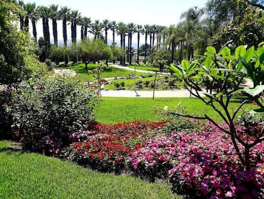 Vista panorámica del Parque de los Pueblos de América con jardines floridos y palmeras