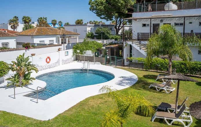 Vista aérea de la piscina del hotel rodeada de césped y tumbonas