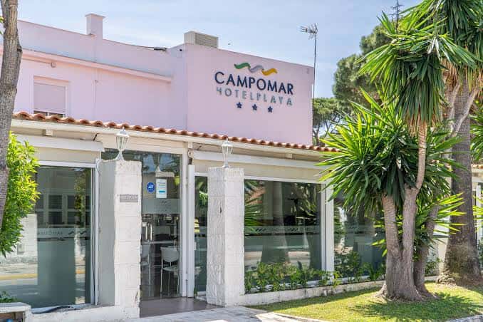 Fachada principal del Hotel Campomar Playa con entrada y palmeras