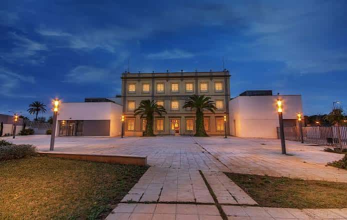 Fachada principal de La Harinera del Guadaíra iluminada al atardecer