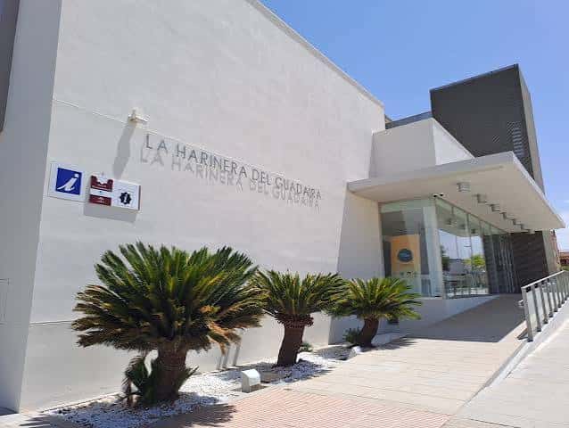 Entrada moderna del centro con señalización y palmeras