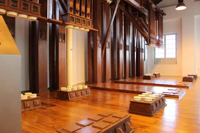 Sala de exposiciones con maquinaria histórica de madera y suelo de parquet