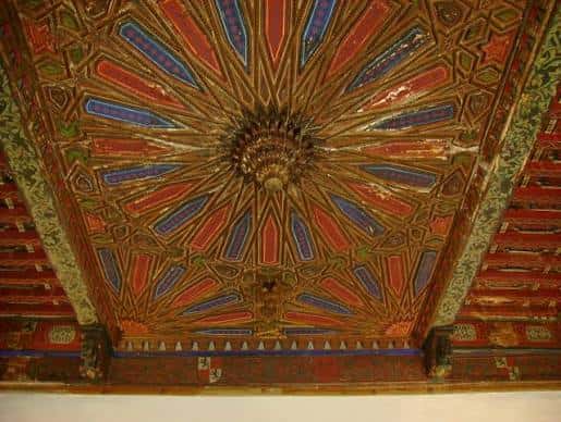 Detalle del artesonado mudéjar con motivos geométricos policromados en el techo