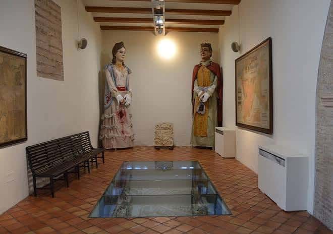 Sala de exposiciones con maniquíes históricos y vitrina de cristal