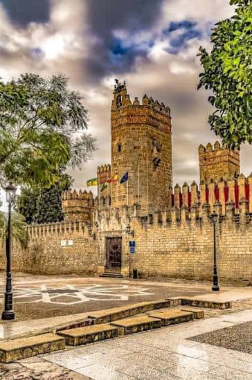 Fachada principal del castillo con bandera y detalles arquitectónicos medievales