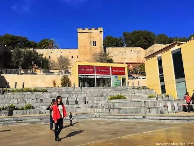 Plaza del Consell con el castillo de fondo y carteles de eventos en el edificio