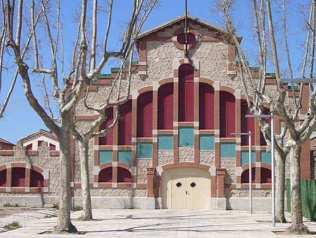 Fachada principal del antiguo matadero de Igualada, ahora espacio cultural, con arcos rojos y detalles arquitectónicos modernistas