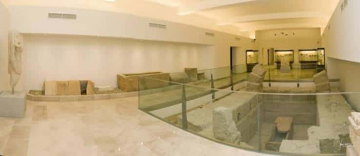 Interior del museo con exposición de restos arqueológicos y vitrinas de cristal