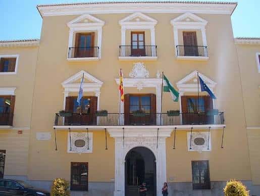 Fachada principal del Ayuntamiento de Motril en la plaza, con banderas y balcones ornamentados