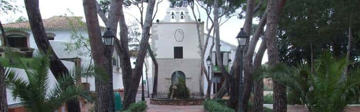 Vista panorámica de la Ermita de la Mare de Déu de Gràcia rodeada de árboles y jardines
