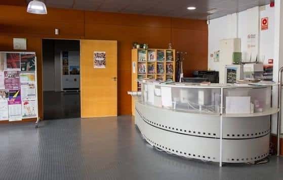 Recepción del centro con mostrador curvo y estanterías informativas