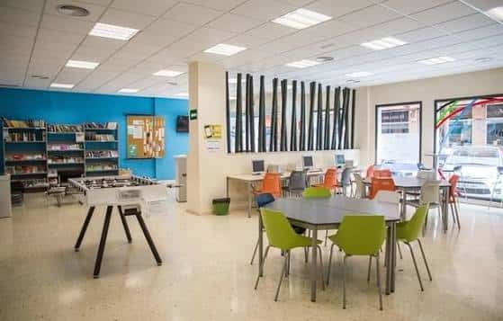Interior del centro mostrando zona de lectura y mesas de trabajo