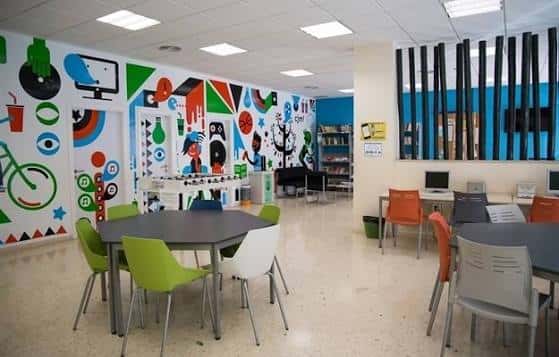 Sala de actividades con decoración colorida y mesas para eventos