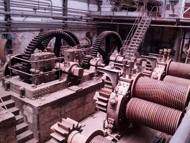 Interior de la fábrica mostrando maquinaria industrial histórica en funcionamiento