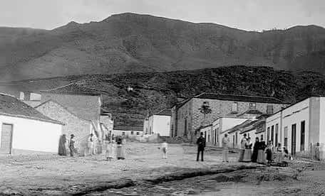 Escena rural de la Calle Grande en Adeje con montañas de fondo y edificaciones sencillas