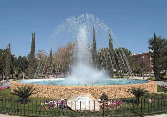 Fuente ornamental con diseño circular y vegetación decorativa