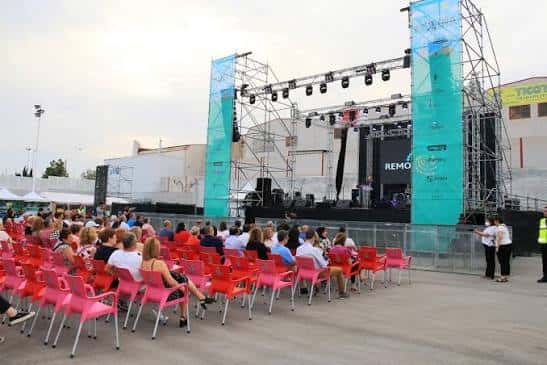 Vista general del escenario principal en el exterior del recinto REMO con público sentado