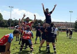 Jugadores de rugby en acción realizando un scrum bajo el sol